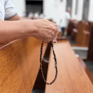 Homens em oração no encontro semanal do Terço
